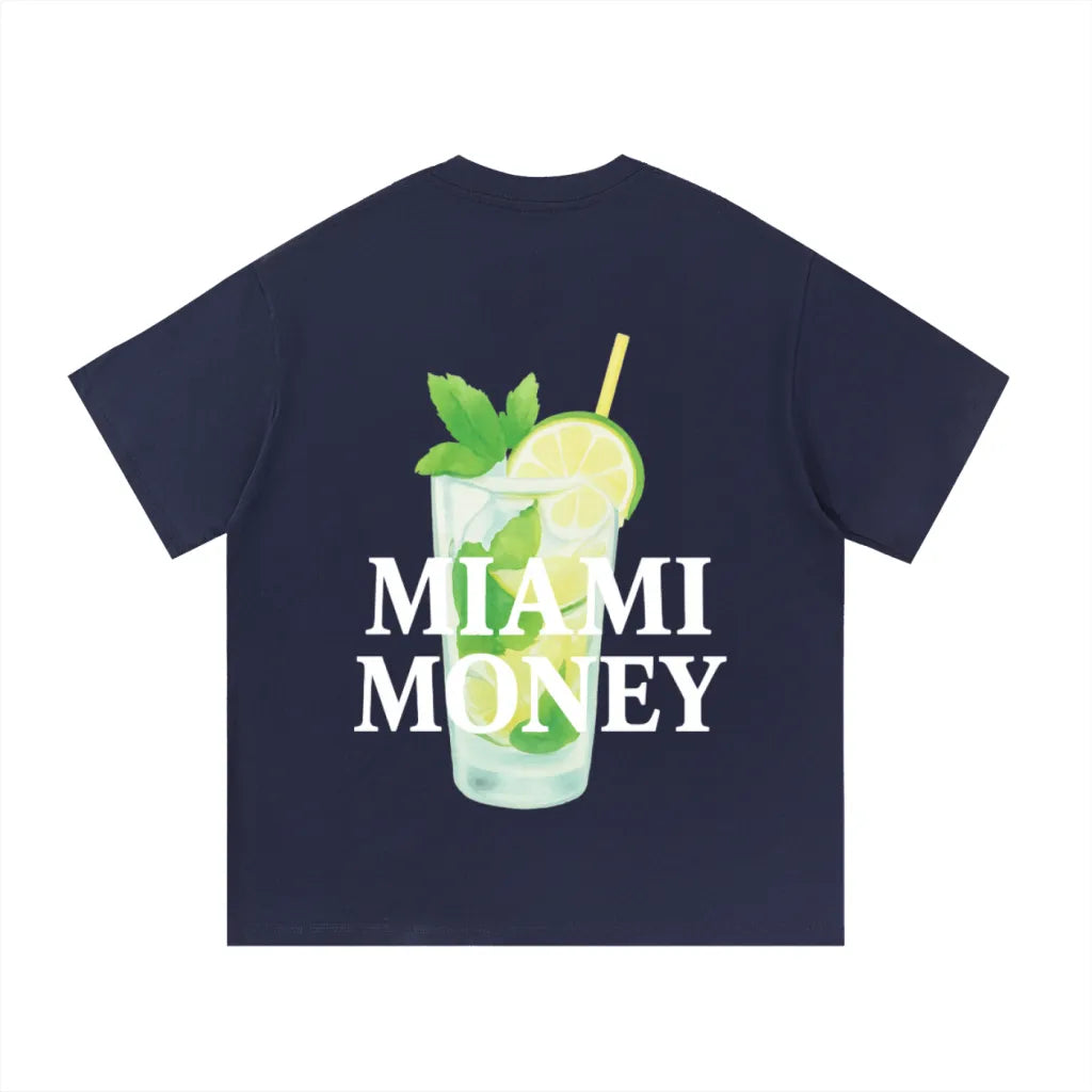 Miami Money navy blue t-shirt (back view) featuring a large white “MIAMI MONEY” logo layered over a beachy mojito cocktail illustration—clear glass with ice, lime slices, fresh mint leaves, and a yellow straw—coastal summer streetwear graphic inspired by Miami beach vibes on a deep navy background.