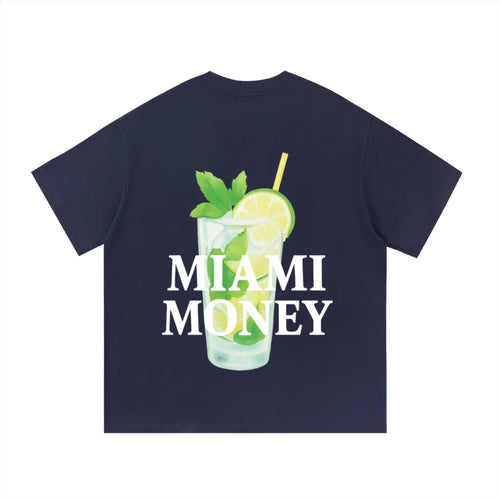 Miami Money navy blue t-shirt (back view) featuring a large white “MIAMI MONEY” logo layered over a beachy mojito cocktail illustration—clear glass with ice, lime slices, fresh mint leaves, and a yellow straw—coastal summer streetwear graphic inspired by Miami beach vibes on a deep navy background.
